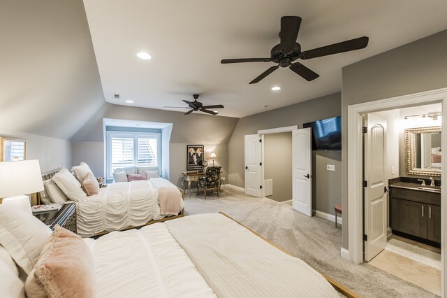 carpeted bedroom featuring connected bathroom, lofted ceiling, ceiling fan, and sink