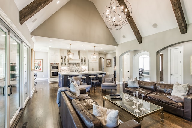 living room with dark wood-type flooring, high vaulted ceiling, beamed ceiling, sink, and a notable chandelier