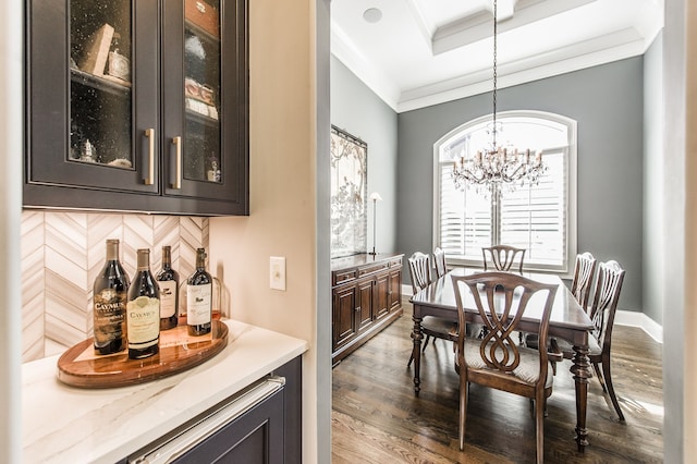 dining area featuring an inviting chandelier, ornamental molding, and dark hardwood / wood-style flooring