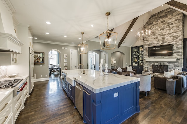 kitchen featuring blue cabinets, vaulted ceiling with beams, a large island, and hanging light fixtures