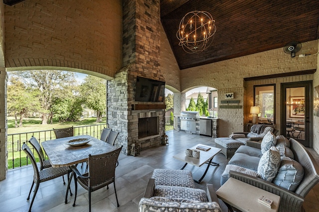 view of patio featuring an outdoor living space with a fireplace, area for grilling, and an outdoor kitchen