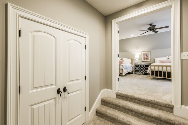 carpeted bedroom featuring ceiling fan and a closet