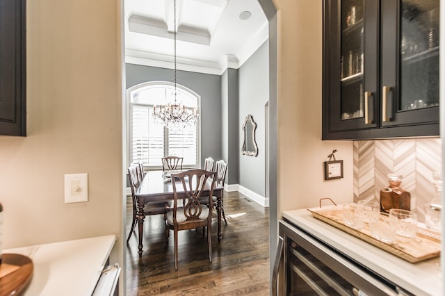 dining room with an inviting chandelier, crown molding, dark hardwood / wood-style flooring, and beverage cooler