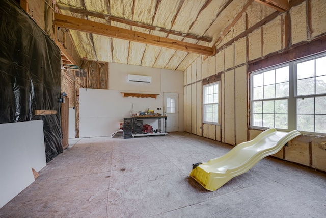 misc room featuring lofted ceiling and a wall mounted air conditioner