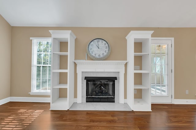 unfurnished living room featuring hardwood / wood-style floors and built in features