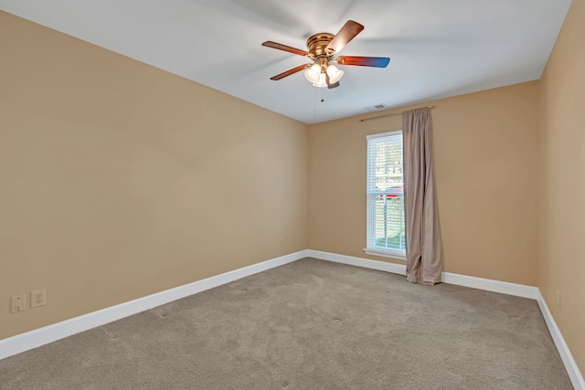 carpeted spare room featuring ceiling fan