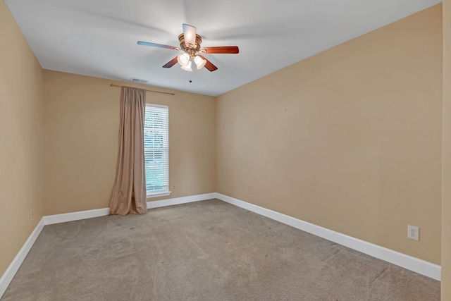 empty room featuring ceiling fan and light colored carpet