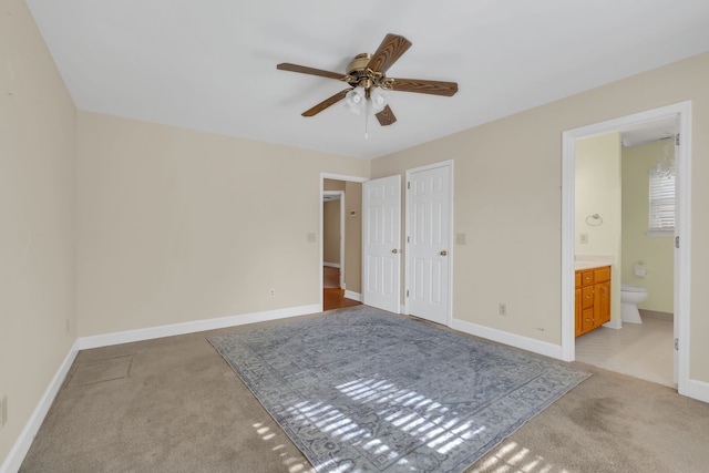 unfurnished bedroom featuring connected bathroom, ceiling fan, a closet, and light colored carpet