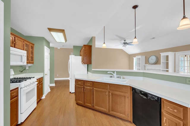 kitchen with sink, hanging light fixtures, light hardwood / wood-style flooring, lofted ceiling, and white appliances