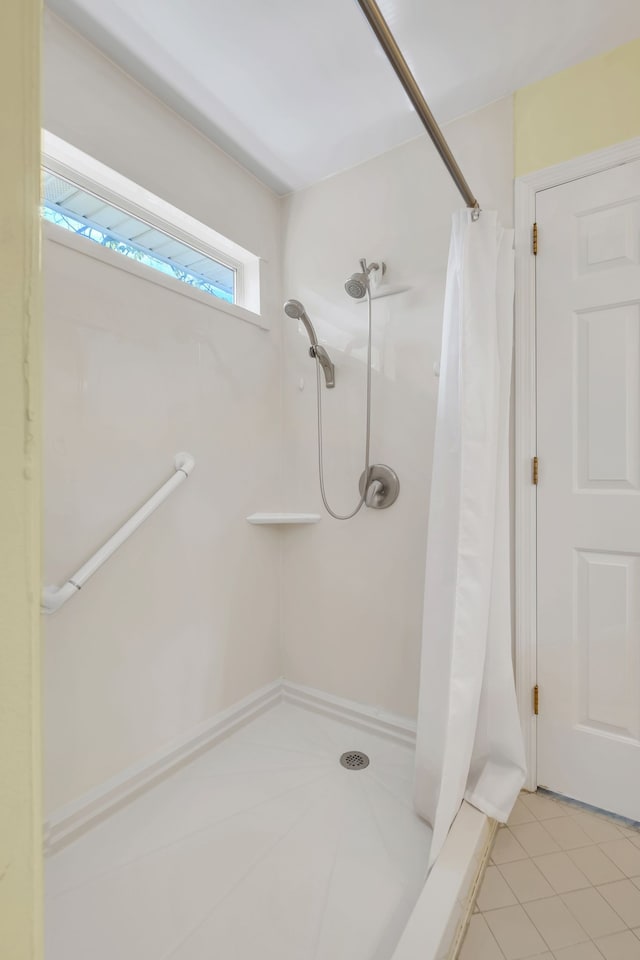 bathroom featuring curtained shower and tile patterned flooring