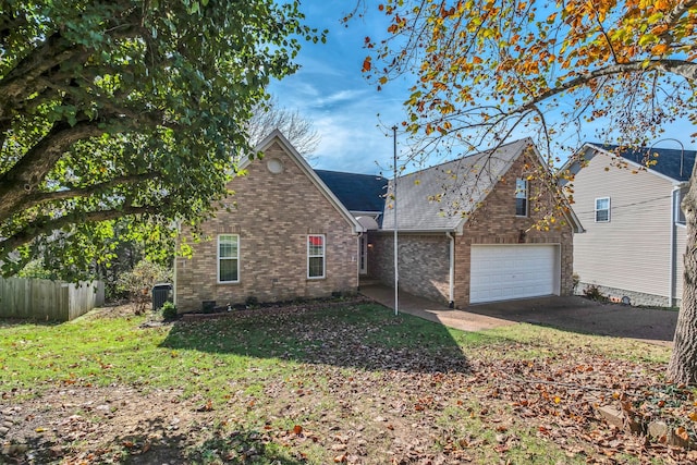 front of property featuring central AC, a front lawn, and a garage