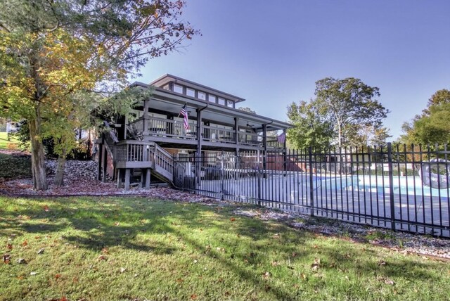 rear view of property with a yard and a covered pool