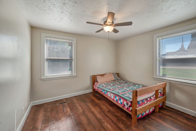 bedroom featuring a textured ceiling, dark hardwood / wood-style flooring, and ceiling fan