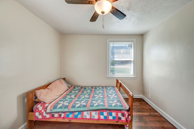 bedroom featuring ceiling fan, dark hardwood / wood-style floors, and a textured ceiling