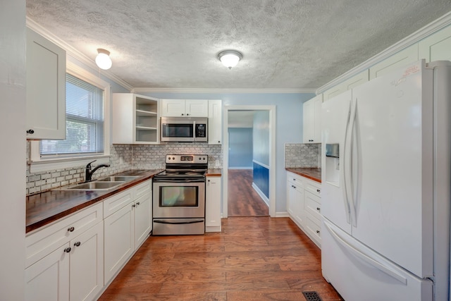 kitchen with dark hardwood / wood-style flooring, sink, stainless steel appliances, and white cabinets