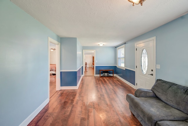 entryway with a textured ceiling and dark hardwood / wood-style flooring