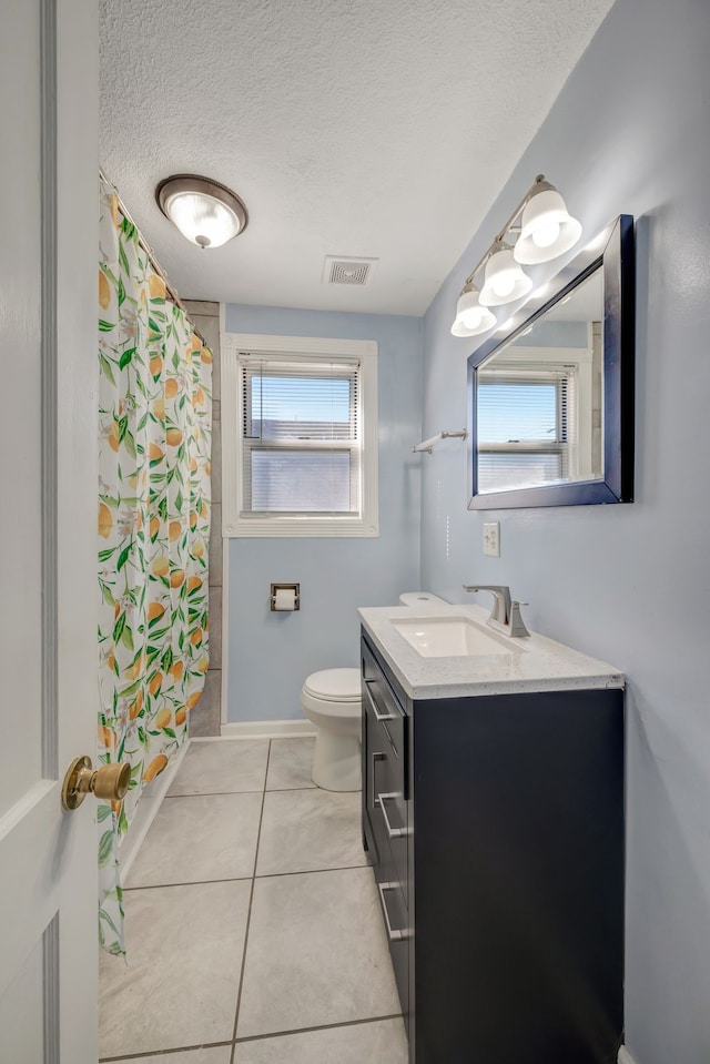 bathroom featuring vanity, tile patterned floors, toilet, and a healthy amount of sunlight