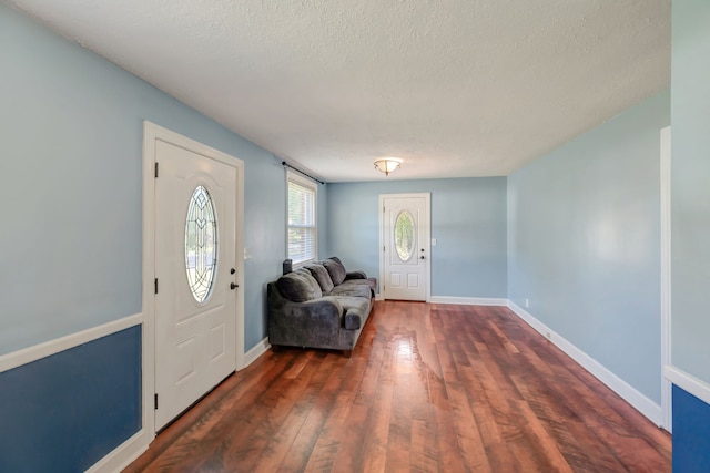 entrance foyer featuring a textured ceiling and dark hardwood / wood-style flooring