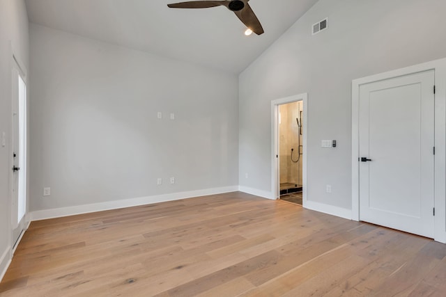 interior space with ceiling fan, ensuite bathroom, light hardwood / wood-style floors, and high vaulted ceiling