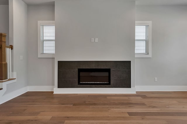 room details with hardwood / wood-style floors and a tile fireplace