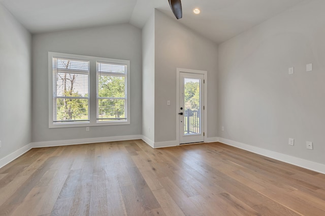 empty room with lofted ceiling and light hardwood / wood-style floors