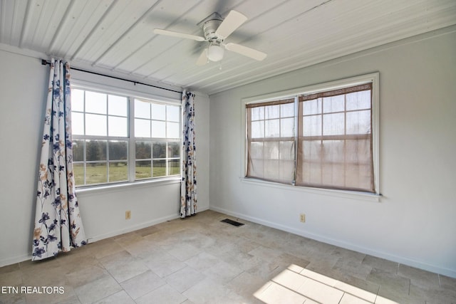 empty room with ceiling fan, baseboards, and visible vents