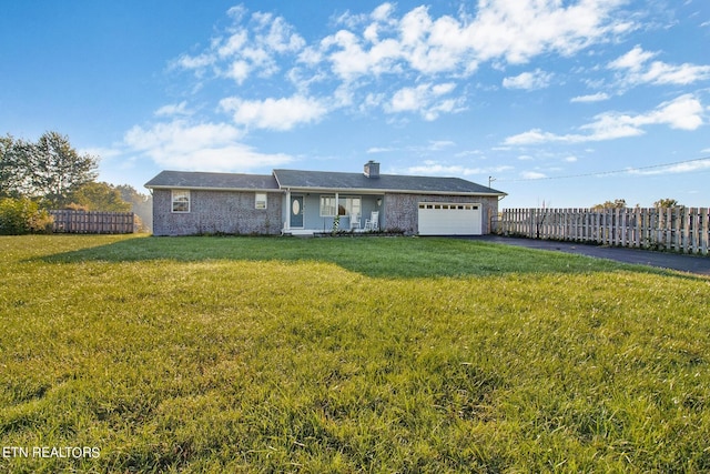 single story home with an attached garage, aphalt driveway, fence, and a front lawn