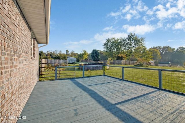 wooden terrace with a yard and a storage unit