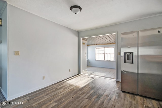 unfurnished dining area featuring baseboards and wood finished floors