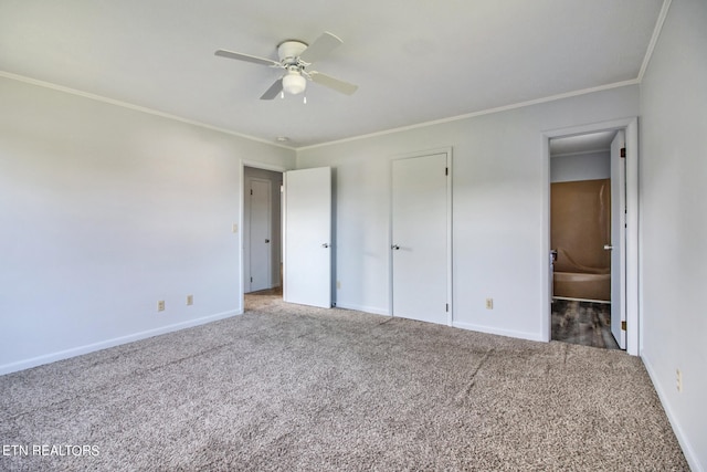 unfurnished bedroom featuring ceiling fan, ensuite bath, carpet flooring, and crown molding