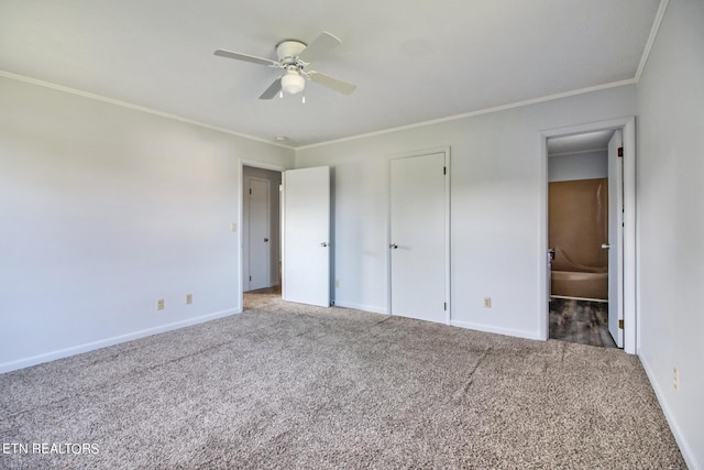 unfurnished bedroom with baseboards, crown molding, and carpet floors
