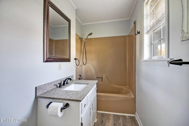 full bath with vanity, baseboards,  shower combination, crown molding, and wood finished floors