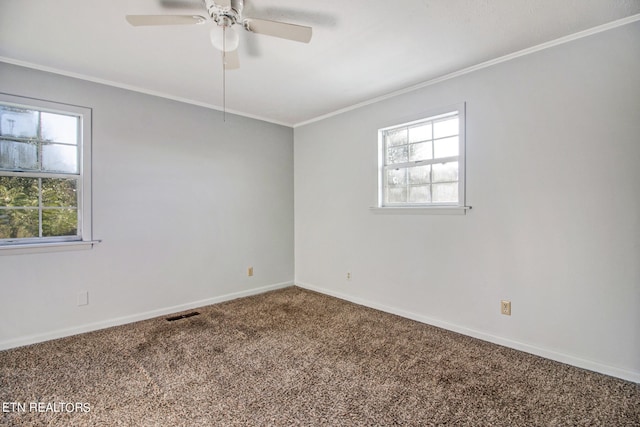 empty room with a healthy amount of sunlight, carpet flooring, crown molding, and ceiling fan