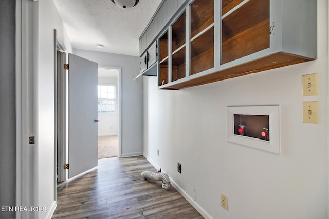 laundry room featuring baseboards, wood finished floors, hookup for a washing machine, and laundry area