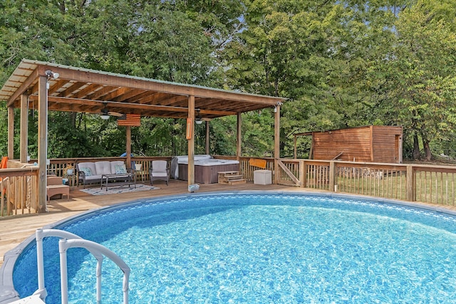 view of pool with ceiling fan, an outdoor living space, a deck, and a hot tub