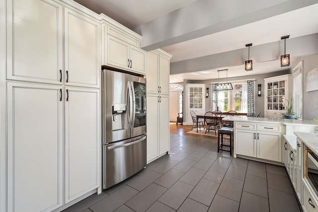 kitchen featuring decorative light fixtures, stainless steel fridge, and kitchen peninsula