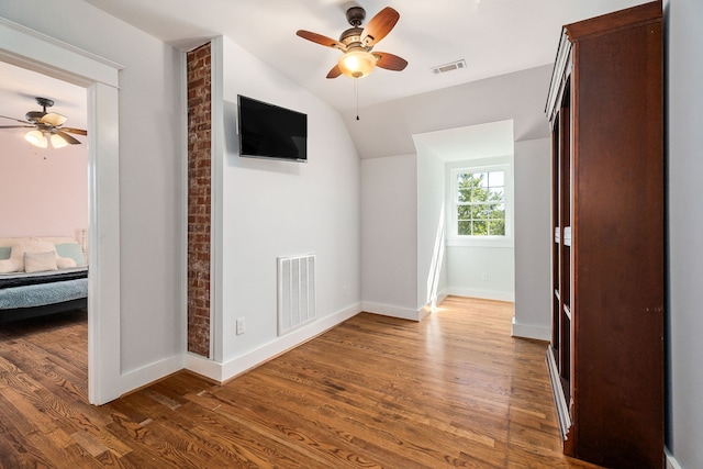 interior space featuring ceiling fan, lofted ceiling, and dark hardwood / wood-style floors