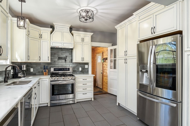 kitchen with premium range hood, sink, tasteful backsplash, decorative light fixtures, and stainless steel appliances