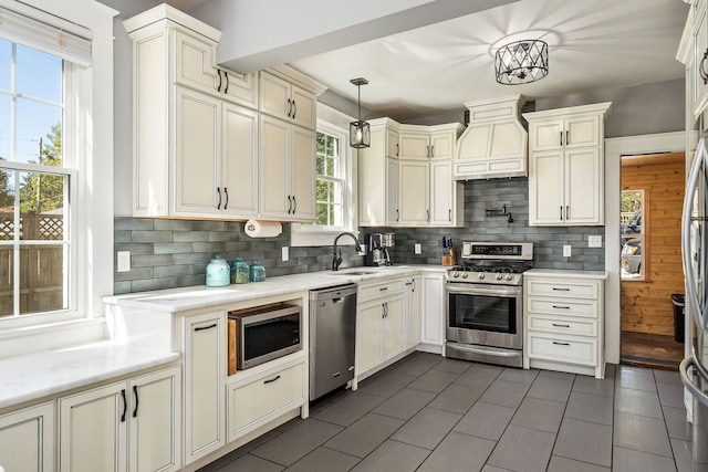 kitchen with decorative backsplash, hanging light fixtures, stainless steel appliances, and custom exhaust hood