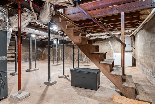 basement with white refrigerator and electric panel