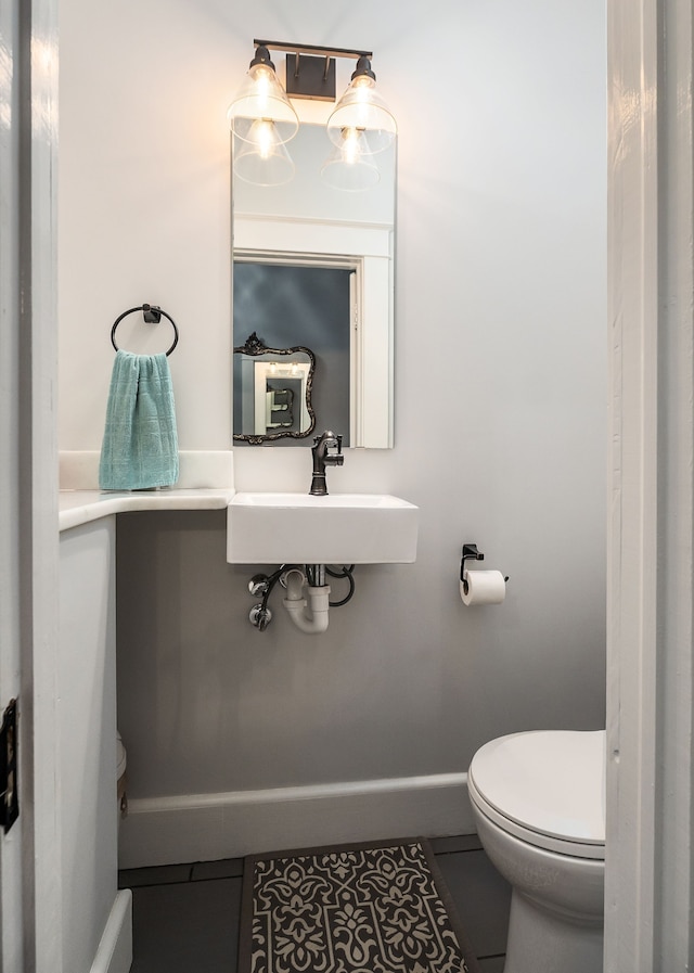 bathroom with sink, toilet, and tile patterned floors