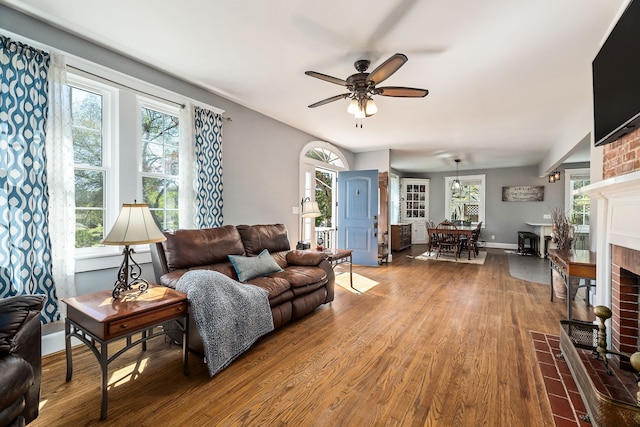 living room with a fireplace, wood-type flooring, and ceiling fan