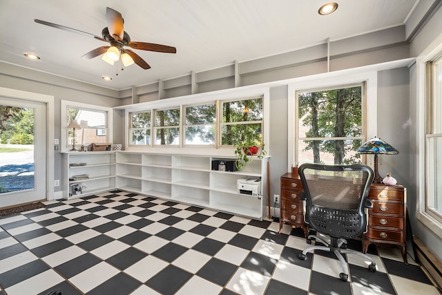 sunroom with ceiling fan, plenty of natural light, and baseboard heating