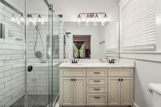 bathroom with a shower with shower door, vanity, and toilet