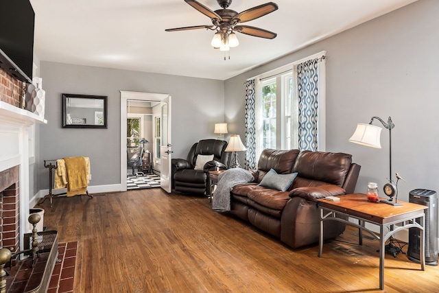 living room featuring ceiling fan, a brick fireplace, and hardwood / wood-style flooring