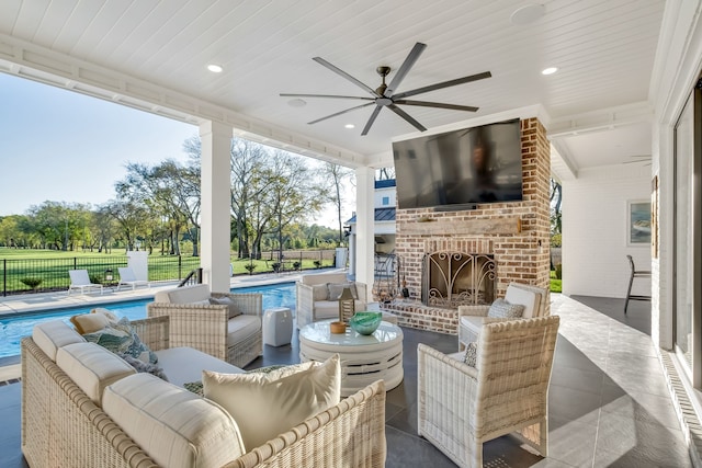 view of patio / terrace with an outdoor living space with a fireplace, a fenced in pool, and ceiling fan