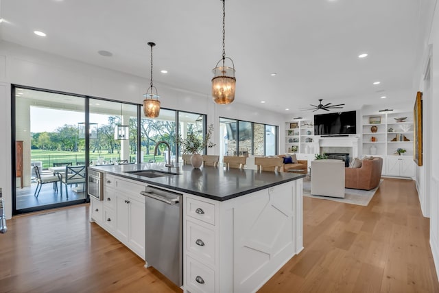 kitchen with light hardwood / wood-style floors, plenty of natural light, sink, and white cabinetry