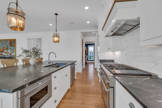 kitchen with pendant lighting, white cabinetry, appliances with stainless steel finishes, and sink