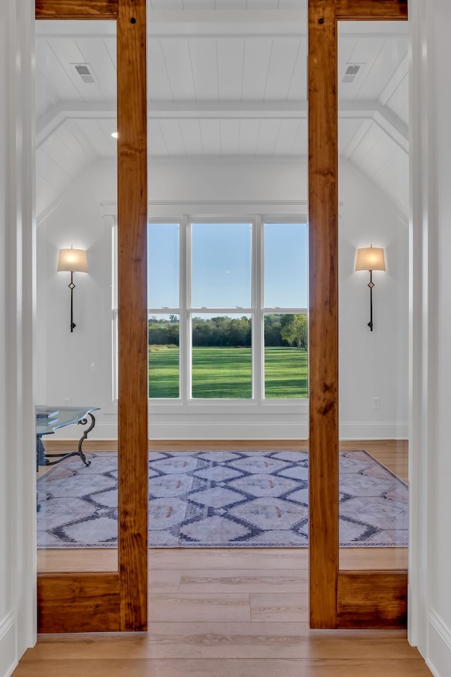 doorway with vaulted ceiling with beams and light hardwood / wood-style flooring