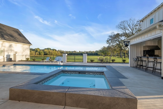 view of pool with a patio and an in ground hot tub